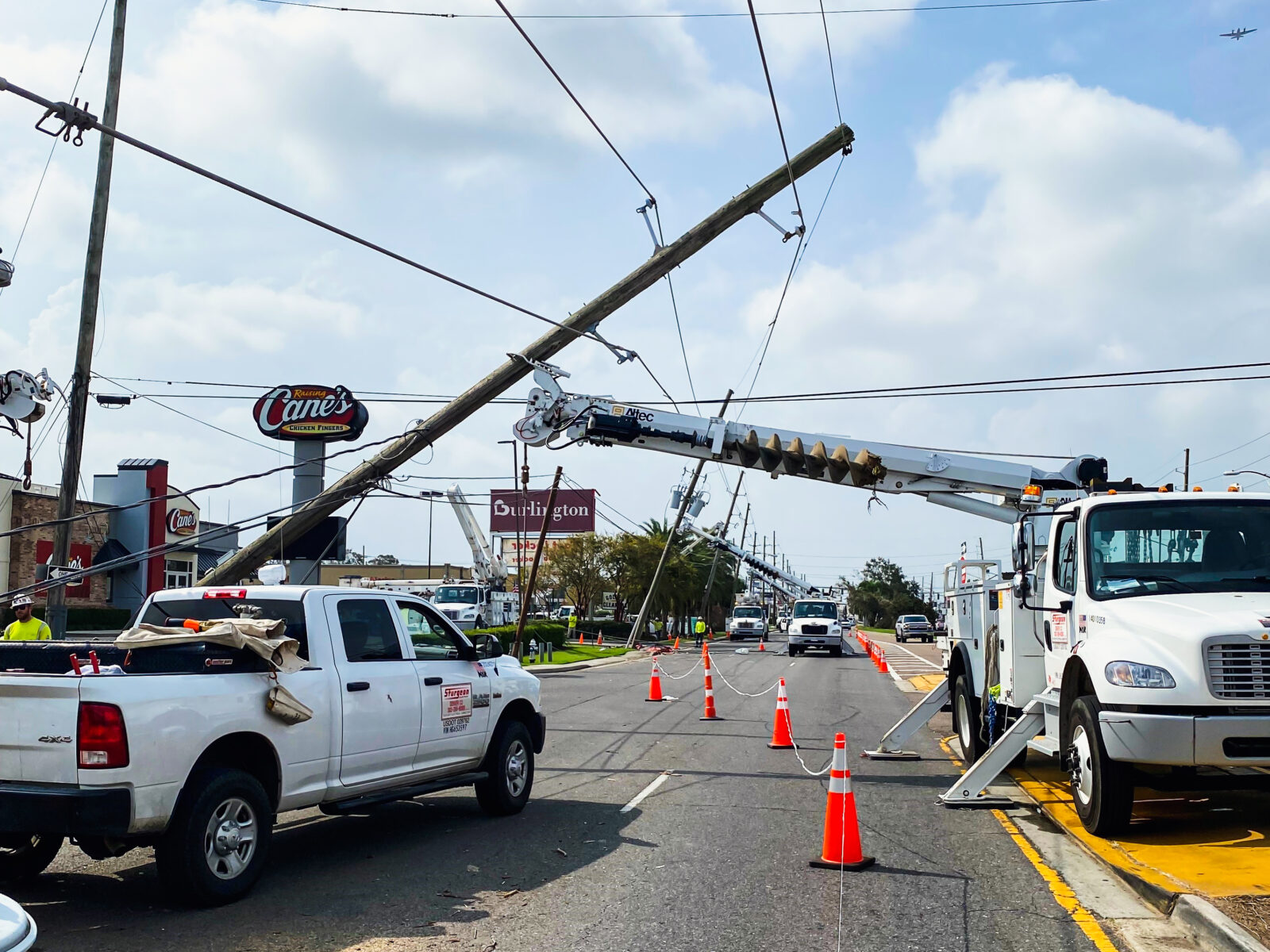 Restoration workers fixing power lines using trucks with cranes
